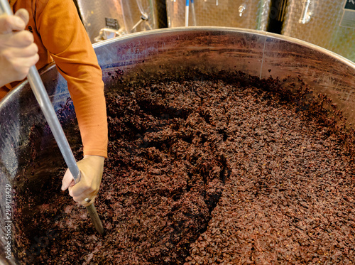Tableau sur toile stirring and mixing barrique pinot noir grapes fermenting in an open tank during