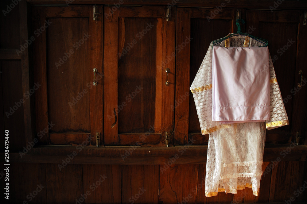 clothes hanging on hanger, White dresses for those who are ordained in Buddhism are hung at the window sill.
