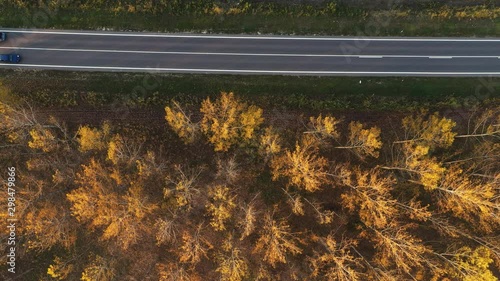 Top view aerial footage of traffic on the road through forest photo