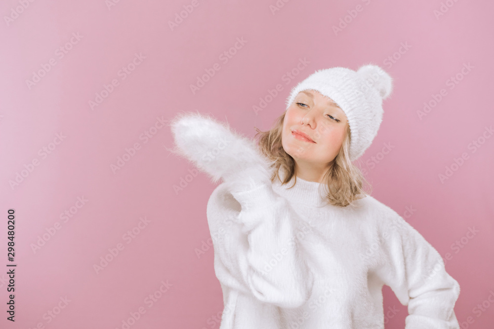 Portrait of young beautiful smiling girl posing isolated on pink background. Girl in fluffy mittens. Looks smiling looking aside. Portrait of young beautiful smiling girl posing isolated on pink background. Girl in fluffy mittens. Looks smiling looking aside.