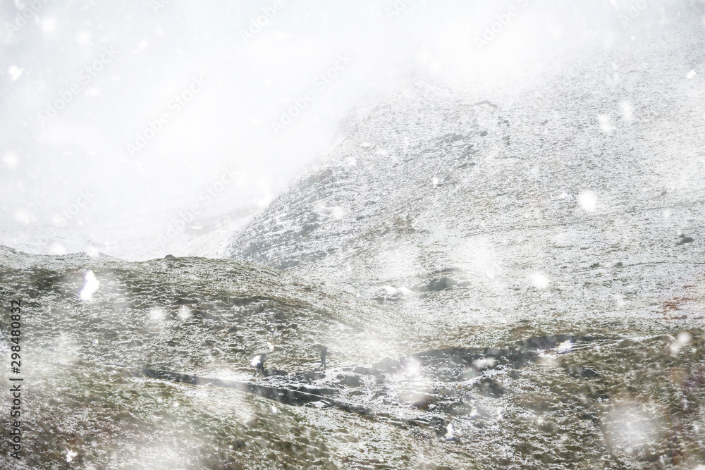 Beautiful Winter landscape image around Mam Tor countryside in Peak District England with hikers in heavy snow storm Beautiful Winter landscape image around Mam Tor countryside in Peak District England with hikers in heavy snow storm
