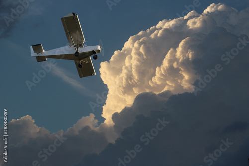 Small private single-propeller plane against the dramatic sky  - digital composite.