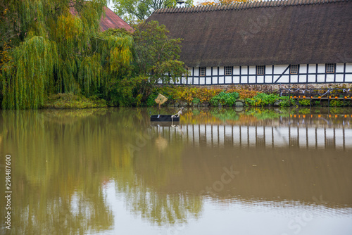 Egeskov Slot, Denmark, Europe: An old stable building with nice reflection in a pond near Egeskov castle in Denmark photo