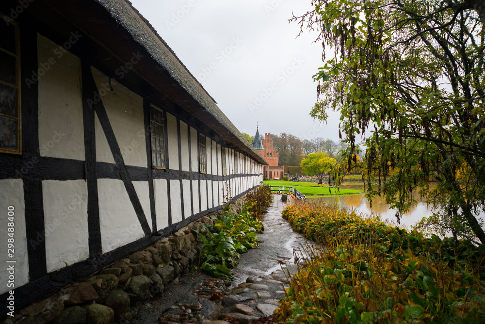 Historic Danish house on the Egeskov castle grounds. Landscape with beautiful autumn. Egeskov Slot, Denmark, Europe Historic Danish house on the Egeskov castle grounds. Landscape with beautiful autumn. Egeskov Slot, Denmark, Europe