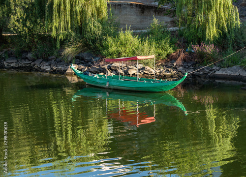 Fishing or rowing boat anchored in the calm waters on the bank of the River Douro in Portugal