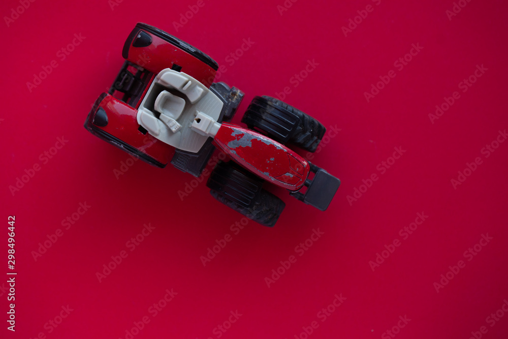 Photo of a toy car on a red background.