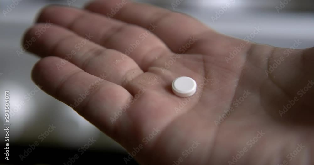 Man holding painkiller pill in his hand Man holding painkiller pill in his hand