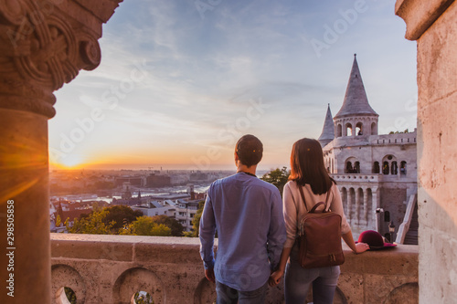 Young couple enjoy the view from the point from Fisherman Bastion in Budapest during sunrise.