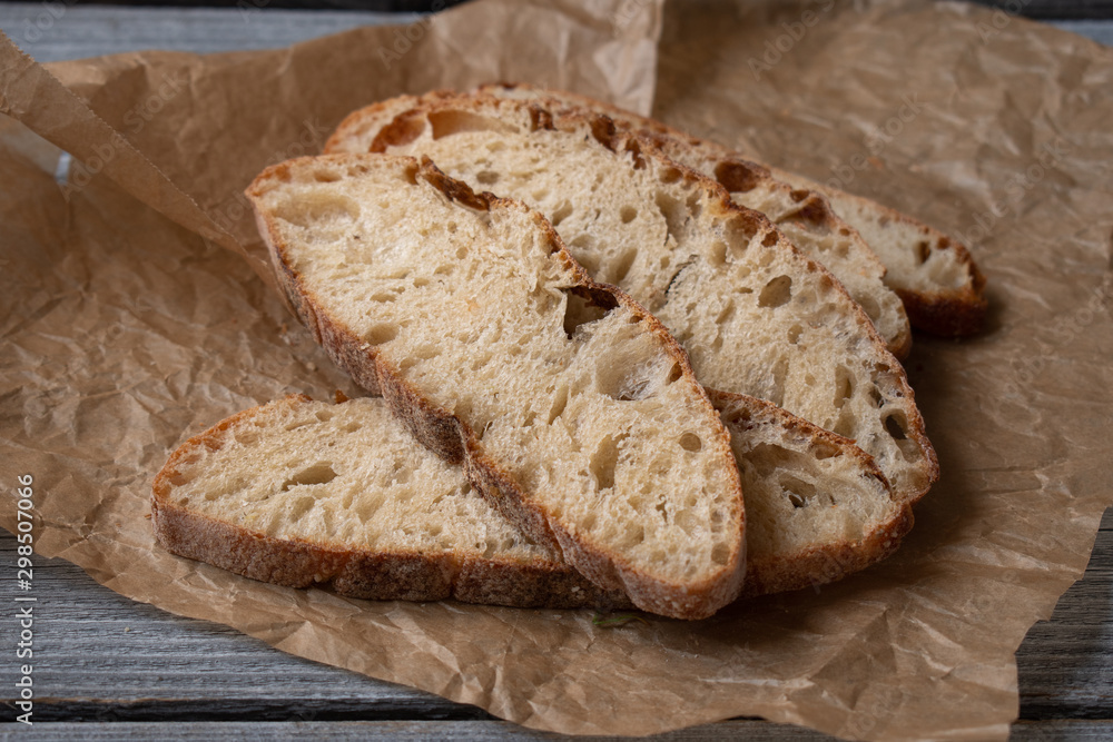 Ciabatta Bread slices on brown paper, wooden table Ciabatta Bread slices on brown paper, wooden table