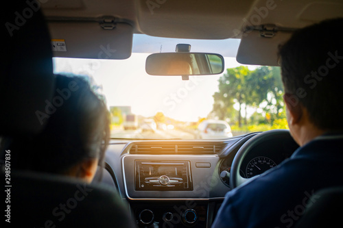 Rear view of couple inside car driving on road, Point of view of driver inside car © AlivePhoto