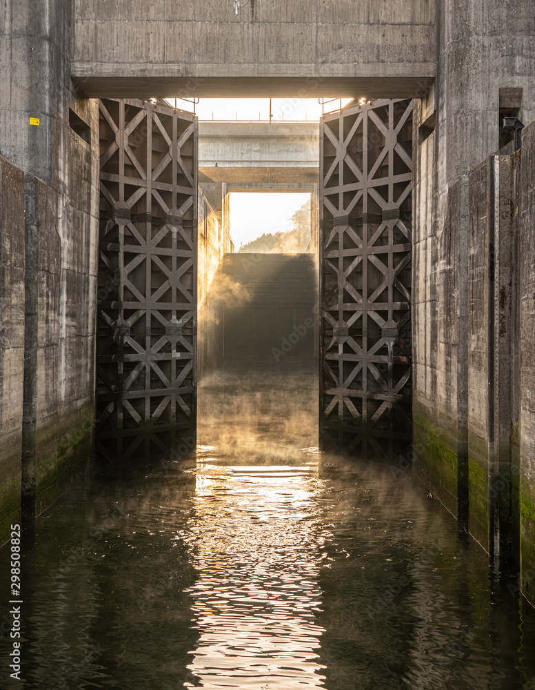 Obraz premium Solid wooden lock gates opening to show the mist from sunrise at the Crestuma Lever dam on River Douro in Portugal
