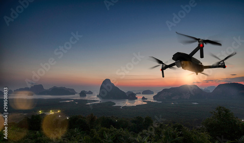 Drone quad copter with high resolution digital camera on the sky mountain and city background.