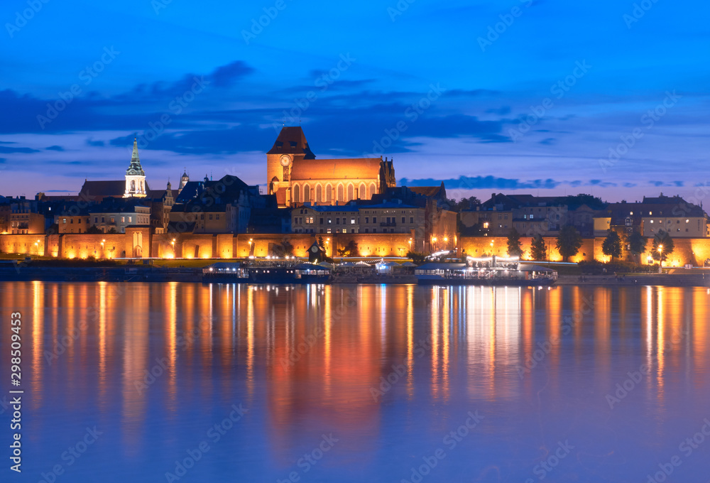 Obraz na płótnie Torun old town in Poland, UNESCO world heritage site, with illumination, reflected in Vistula river at beautiful evening. w salonie