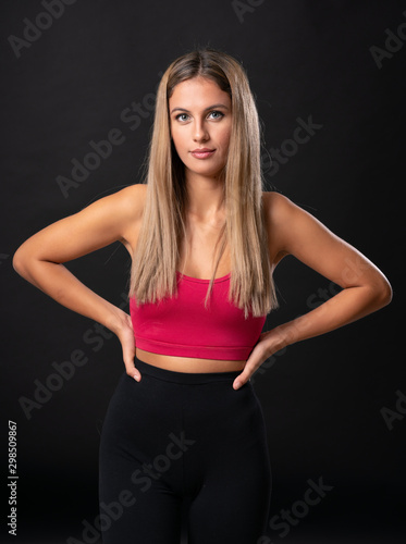 Young sport blonde woman over isolated black background