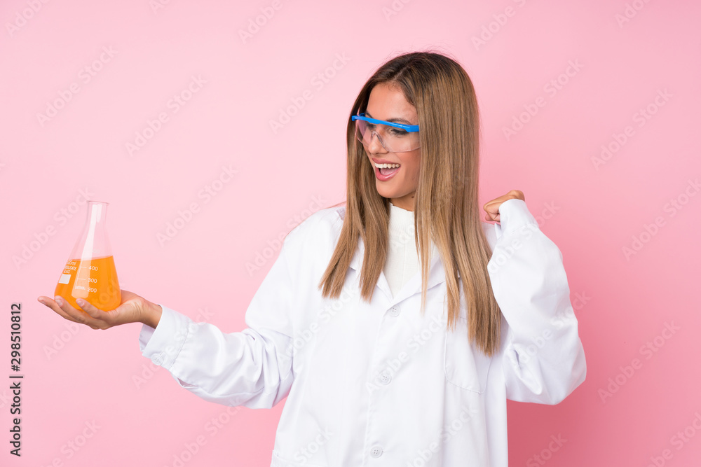 Young blonde woman over isolated pink background with a scientific test tube and celebration Young blonde woman over isolated pink background with a scientific test tube and celebration