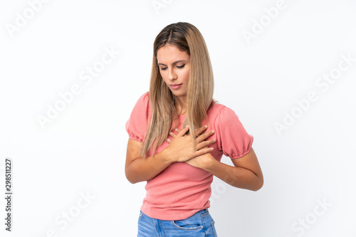 Young blonde woman over isolated white background having a pain in the heart © luismolinero
