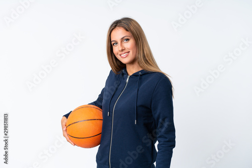 Young woman playing basketball over isolated white background