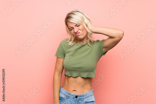 Young blonde woman over isolated pink background with neckache