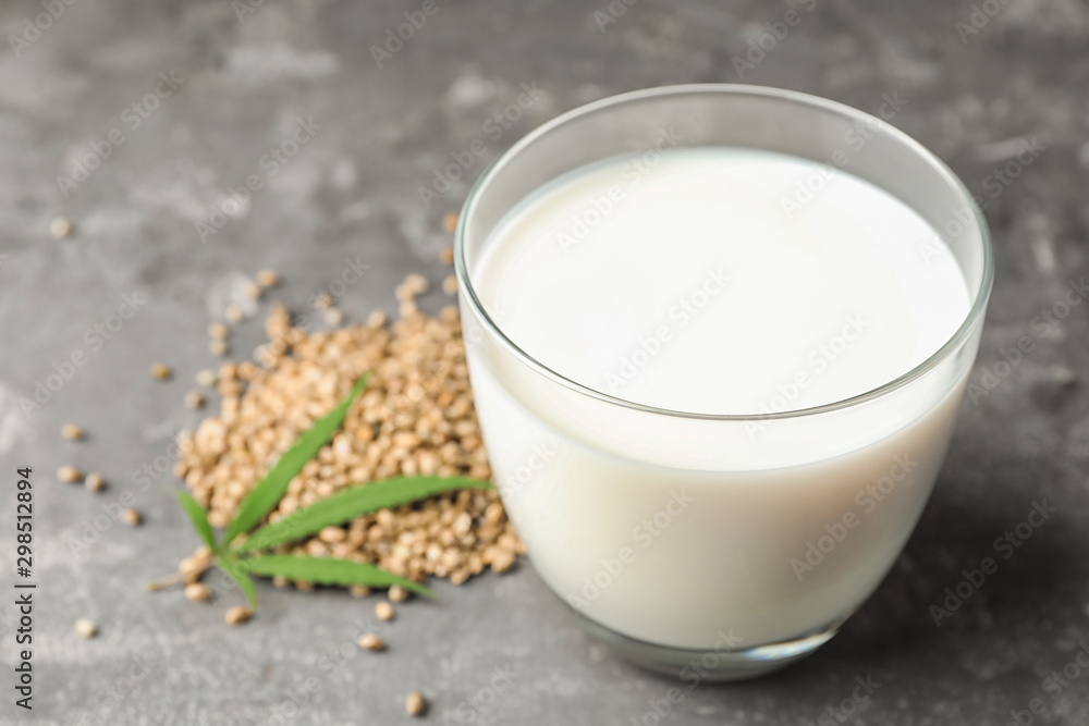Composition with glass of hemp milk on grey table, closeup. Space for text Composition with glass of hemp milk on grey table, closeup. Space for text