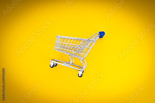 empty shopping cart over yellow background