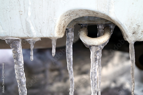 Many large and sharp icicles hang on the car.