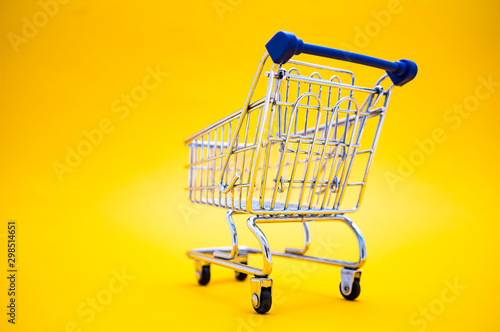 empty shopping cart over colour background