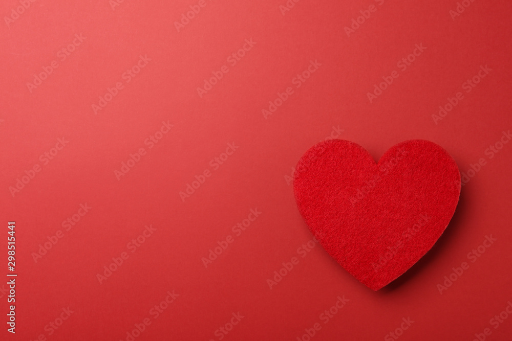 Decorative heart on red background, top view. Space for text