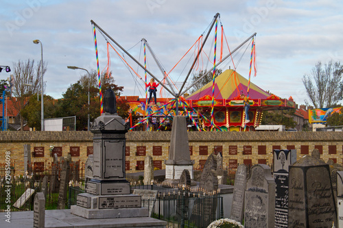 Contrast: sadness and pleasure, fairground adjecent to graveyard