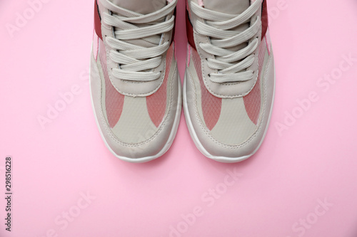 Pair of stylish women's sneakers on pink background, top view