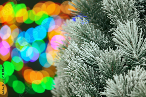 Decorated Christmas tree against blurred festive lights  closeup. Space for text