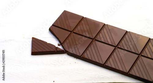 Chocolate bar in crackd bar on white floor