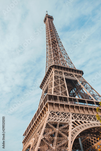 A vertical frame with a view of the Eiffel Tower with a distorted perspective against the sky