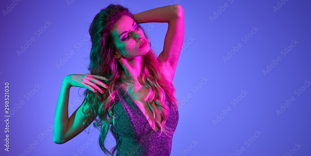 Fototapeta Fashionable glamour woman with Trendy wavy neon light hairstyle. Party night club vibes, gel filter. Excited shapely girl dance. Bright pink green lighting. Art fashion creative neon color.
