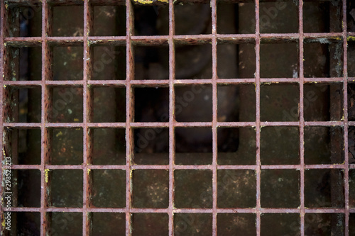 Smelly chamber. Close-up detailed image of the rusty iron grid lid. Mesh square pattern. © mouaad