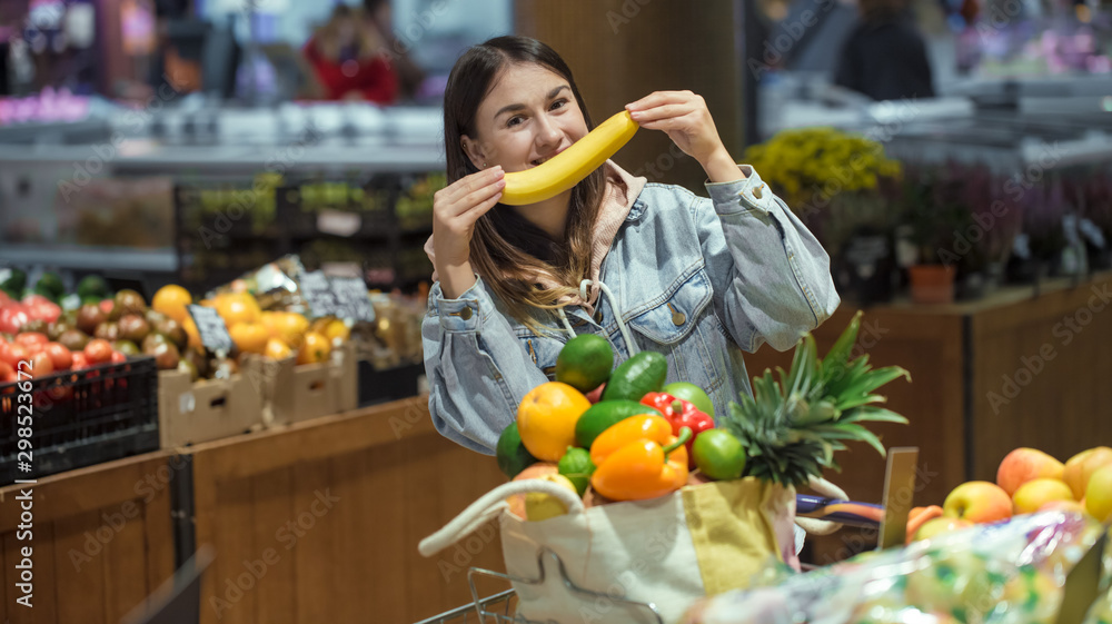 Fototapeta premium A young woman buys groceries in a supermarket.