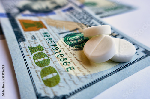 Pills on dollar money isolated on white background. Medicine expenses , one way road photo