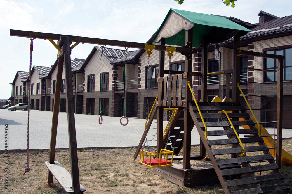 Fototapeta premium Back Yard Wooden Swing Set on Green Lawn