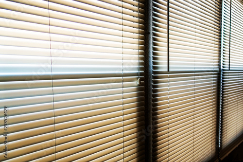 Sunshine hitting closed window blinds in the early morning