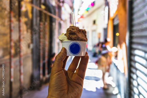 Human hand holding a cup of Italian ice cream with copy space on cup
