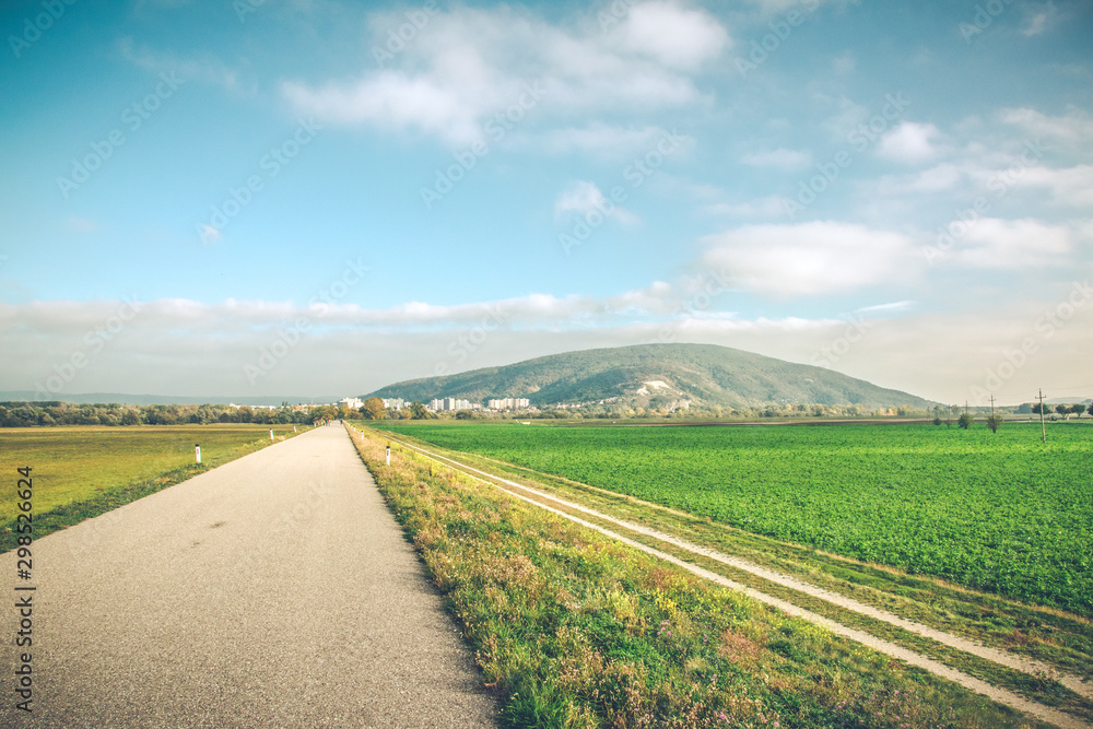 Road landscape with mountain on a sunset. Bicycle trail to Bratislava from Austria. 