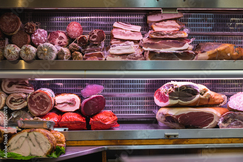 Italian ham and sausages on a shelf in a shop