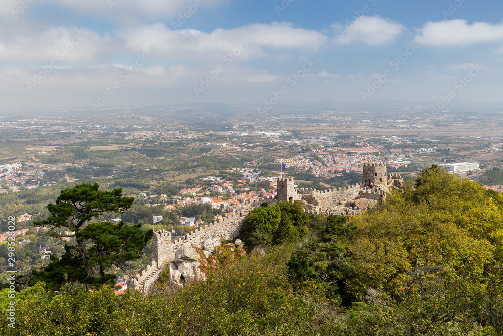Scenic view of medieval hilltop castle Castelo dos Mouros (The Castle of the Moors) and Sintra municipality and beyond from above in Portugal. Scenic view of medieval hilltop castle Castelo dos Mouros (The Castle of the Moors) and Sintra municipality and beyond from above in Portugal.