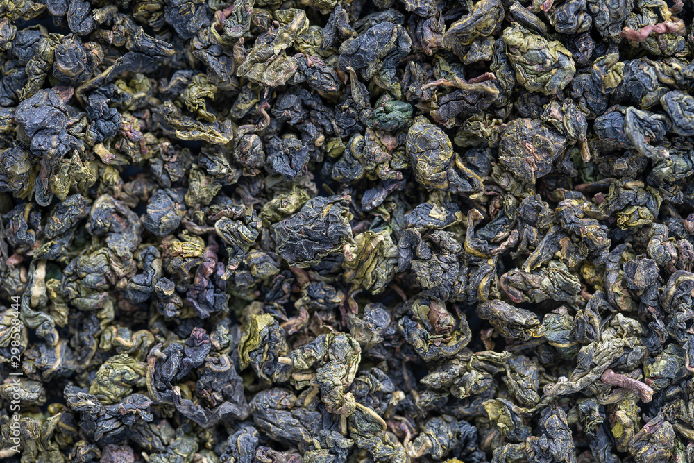 Green tea leaves background. Oolong tea. Abstract food textures. Close up .The high end tea of China. Green tea leaves background. Oolong tea. Abstract food textures. Close up .The high end tea of China.