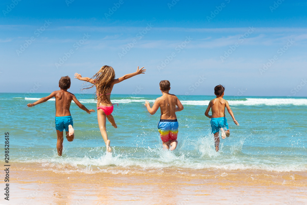 Girl jump into water with friends group on beach