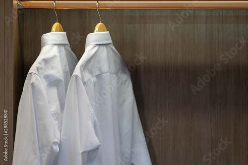 Men shirt hang in a wooden closet at modern home