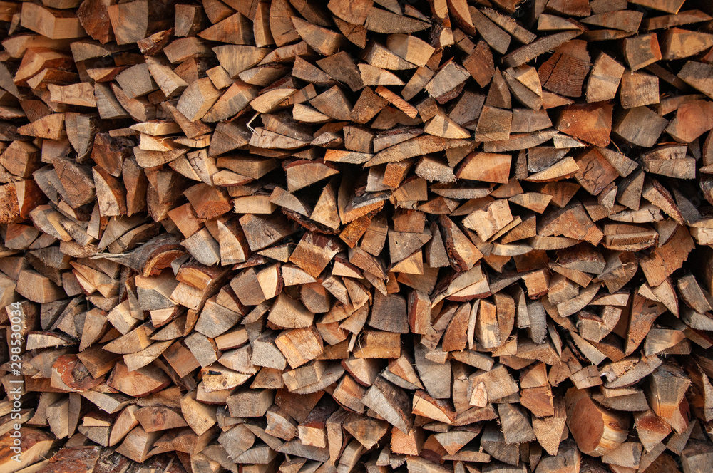 Firewood pile stacked chopped wood trunks for winter heating fireplace. Firewood pile stacked chopped wood trunks for winter heating fireplace.