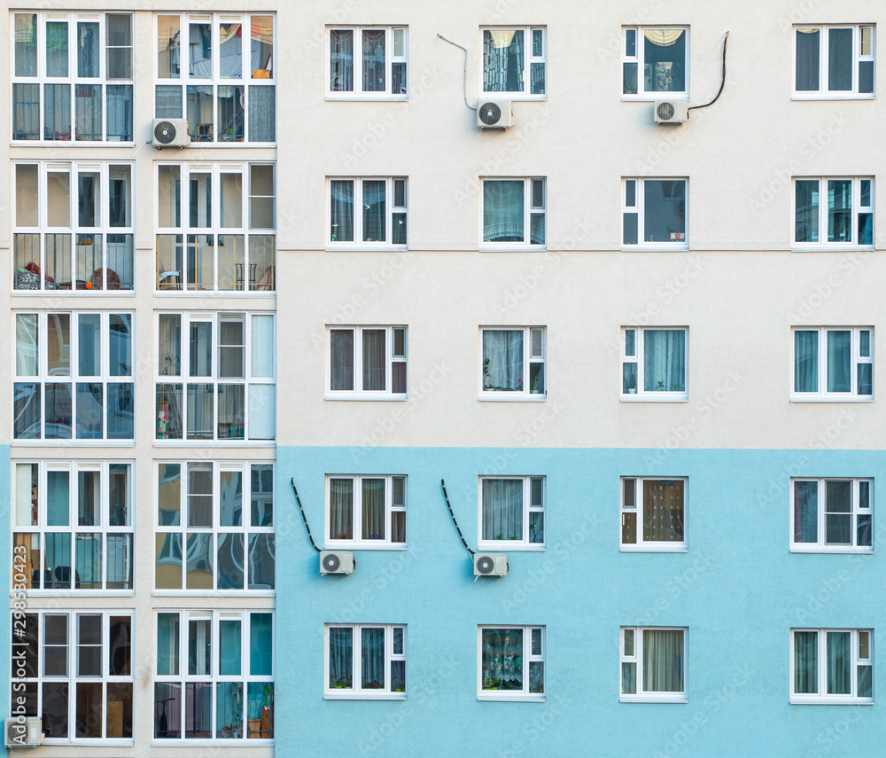 Windows of a multi-storey building opposite the blue-white color. Without people