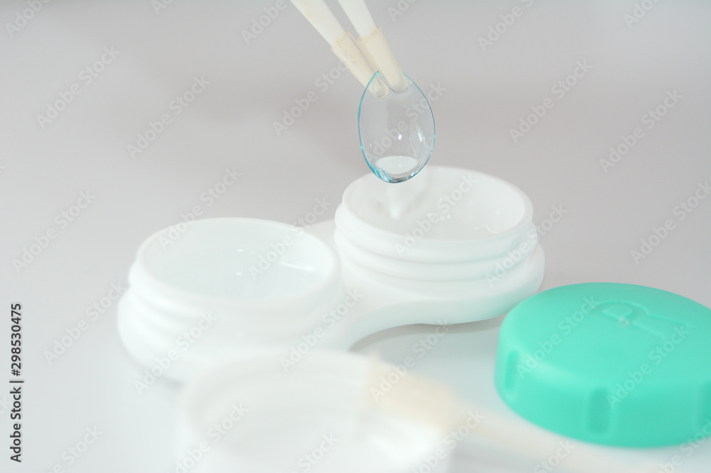 container for soft contact lenses and lens with tweezers on light background container for soft contact lenses and lens with tweezers on light background