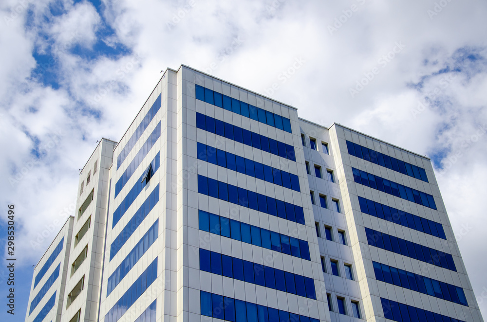 Architectural background, fragment of a modern office building against blue sky with clouds Architectural background, fragment of a modern office building against blue sky with clouds