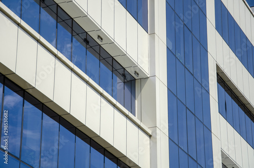 Modern architectural background of metal panels and blue glazing close up